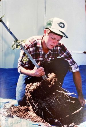 Ben Walker, SuperTrees founder, holding a tree and removing it from air pot for planting.